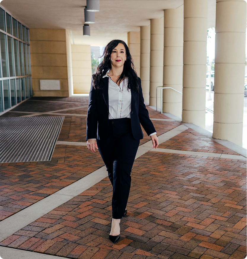Connecticut Estate Planning Attorney - Professional Legal Representation Professional female estate planning attorney in black suit walking confidently through courthouse colonnade
