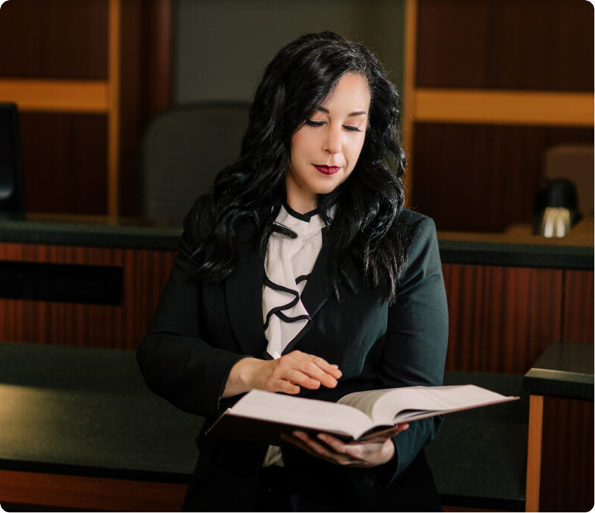 Estate Planning Attorney Reviewing Legal Case Documents Professional female estate planning attorney in black suit reviewing legal documents in courtroom
